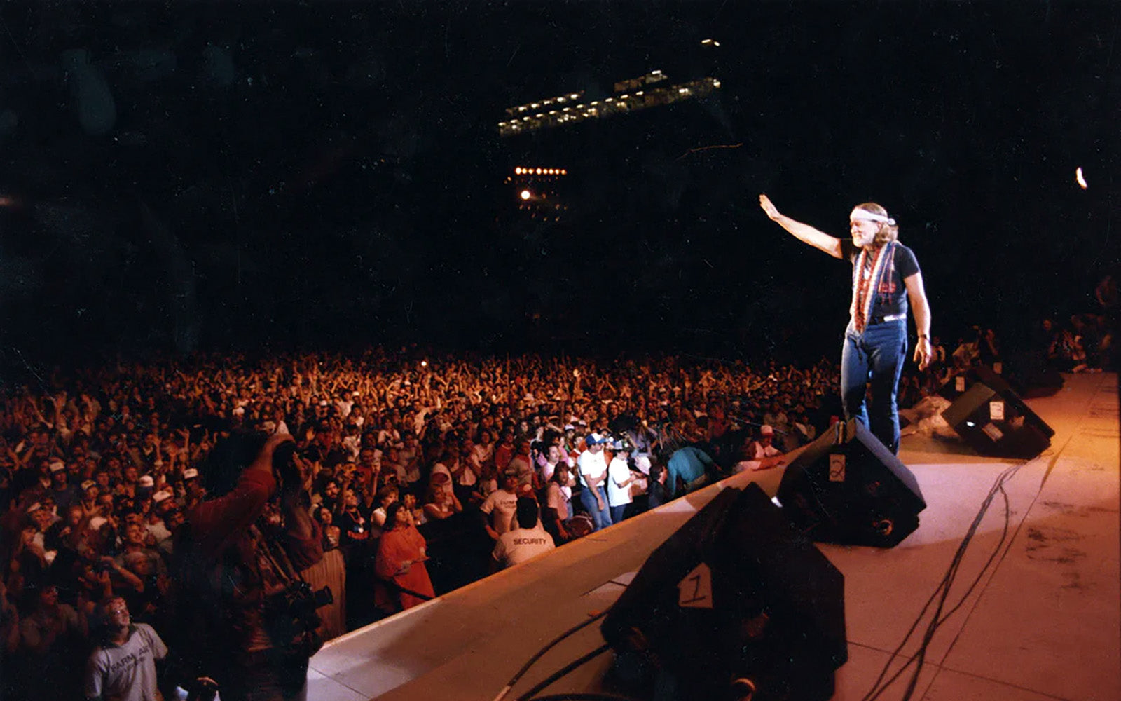 Willie Nelson waving to audience at Farm Aid